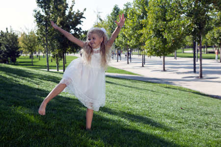 beautiful little girl in a white dress as a portrait closeupの写真素材