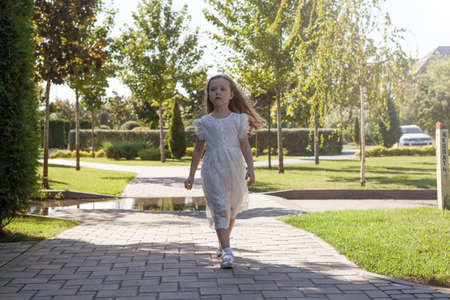 beautiful little girl in a white dress as a portrait closeupの写真素材