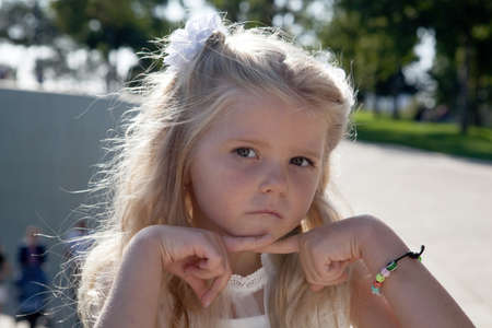 beautiful little girl in a white dress as a portrait closeupの写真素材
