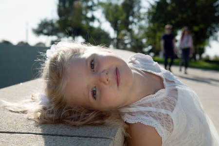 beautiful little girl in a white dress as a portrait closeupの写真素材