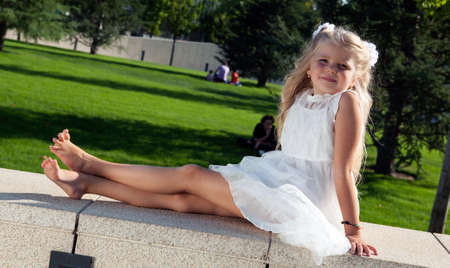 beautiful little girl in a white dress as a portrait closeupの写真素材