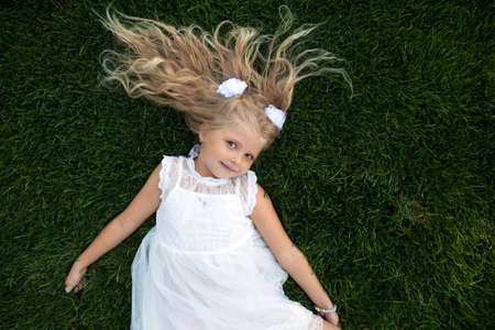beautiful little girl in a white dress as a portrait closeupの写真素材