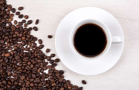 cup of black coffee on a gray wooden background and roasted coffee beansの写真素材