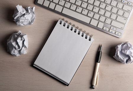 work table, a notebook with a pen and crumpled paper top viewの写真素材
