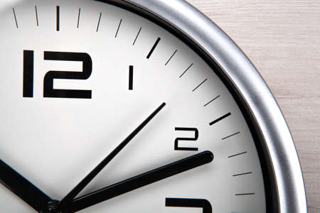 large white clock face with digits on a wooden backgroundの写真素材