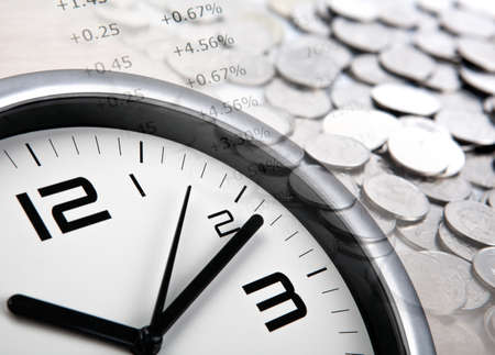 pile of coins with digits and clock face close upの写真素材