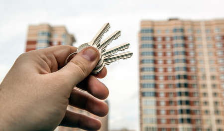 bunch of keys from an apartment in a hand on the background of a new building