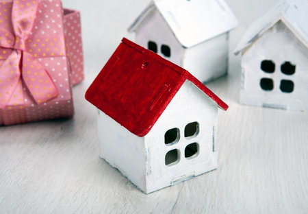 small white wooden house with red roof and gift box closeupの写真素材