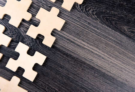 puzzle elements on a wooden background as a riddle top viewの写真素材