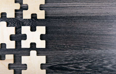 puzzle elements on a wooden background as a riddle top viewの写真素材