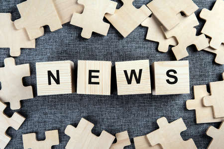 puzzle elements on a textile background as a riddle with inscription news top viewの写真素材