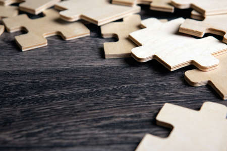 puzzle elements on a wooden background as a riddle closeupの写真素材