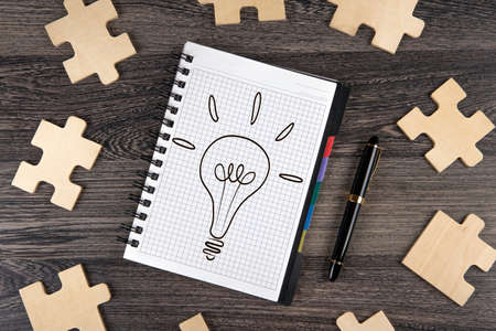 notepad with a pen and puzzle pieces closeupの写真素材