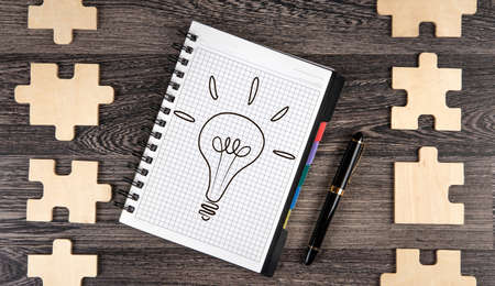 notepad with a pen and puzzle pieces closeupの写真素材