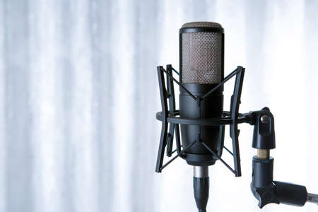 studio black condenser microphone against gray curtains close upの写真素材