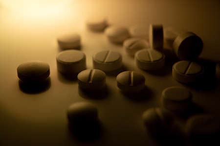white medical pills are scattered on the table closeup