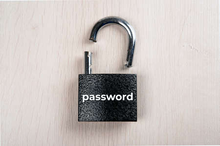 broken padlock with inscription password on a wooden background top view