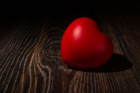 One large red heart on wooden background close upの写真素材