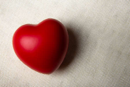 one large red heart on a textile background close upの写真素材