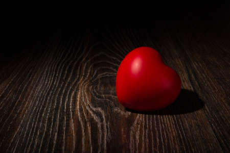 One large red heart on wooden background close upの写真素材