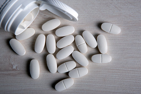 white pills with a jar on a wooden table close upの写真素材