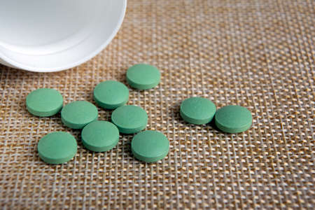 round green pills with a jar on a napkin close upの写真素材