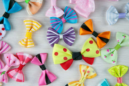 multi-colored decorative fabric bows on a wooden table top viewの写真素材