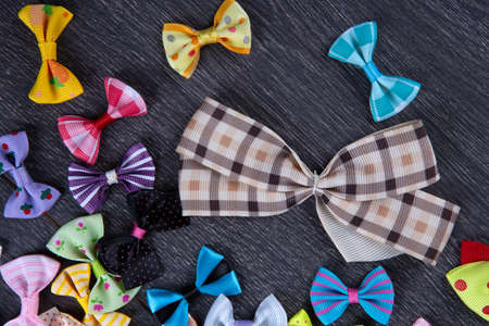 multi-colored decorative fabric bows on a wooden table top viewの写真素材