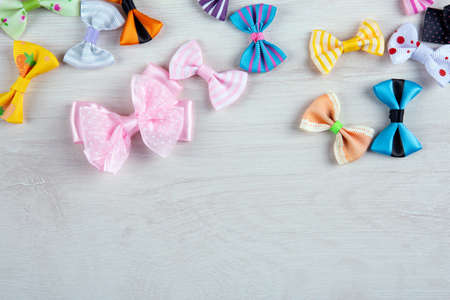 multi-colored decorative fabric bows on a wooden table top viewの写真素材