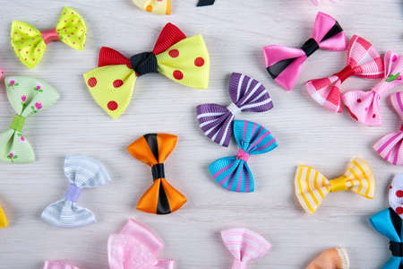multi-colored decorative fabric bows on a wooden table top viewの写真素材