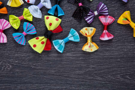 multi-colored decorative fabric bows on a wooden table top viewの写真素材