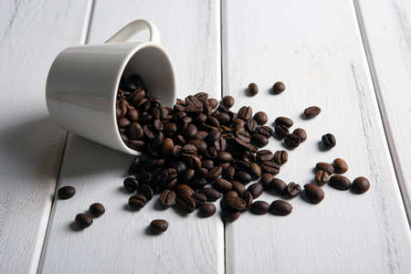 roasted coffee beans in the cup on a white wooden background closeupの写真素材