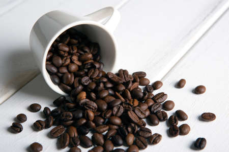 roasted coffee beans in the cup on a white wooden background closeupの写真素材
