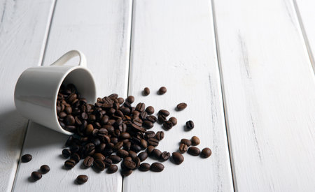 roasted coffee beans in the cup on a white wooden background closeupの写真素材