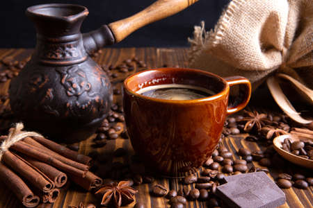 ceramic brown cup with black coffee and grains on woodenの写真素材