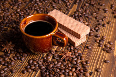 ceramic brown cup with black coffee and grains on woodenの写真素材