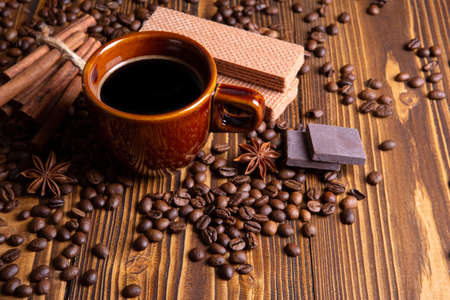ceramic brown cup with black coffee and grains on woodenの写真素材