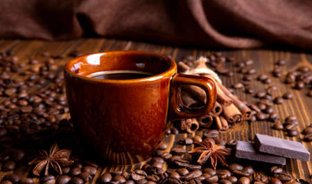 ceramic brown cup with black coffee and grains on woodenの写真素材