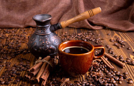 ceramic brown cup with black coffee and grains on woodenの写真素材