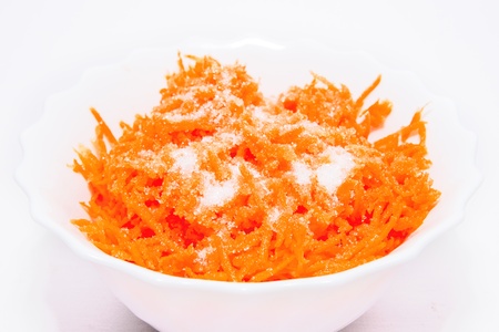 Grated carrots with sugar (vegetarian salad) on white backgroundの写真素材