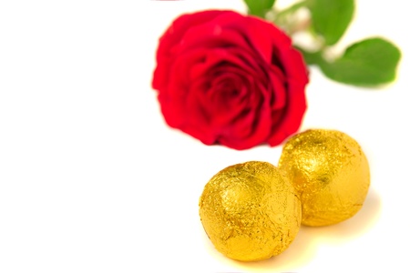Red rose and chocolate candies  isolated on white background. Selective focus.の写真素材