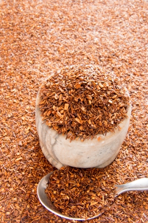 Rooibos tea background with bowl and spoon close up. Selective focus.の写真素材