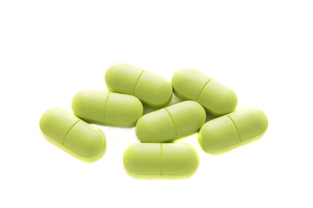 Pile on green pills or tablets isolated on white background.の写真素材