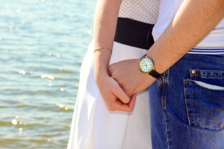 Young couple holding hands with love and tenderness, outdoors, near water  sea, river の写真素材