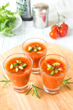 delicious tasty cold tomato soup gazpacho in portion glasses on wooden board, closeup, verticalの写真素材