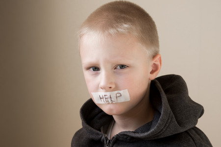 Upset abused frightened little child (boy), help, close up horizontal portrait with copy spaceの写真素材