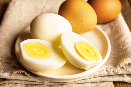 Boiled eggs over rustic linen and wooden backgroundの写真素材