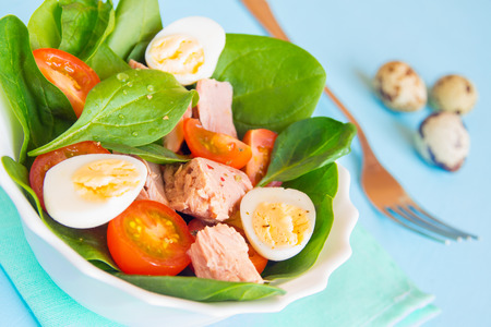 Fresh colorful salad with spinach, tuna, tomatoes and quail eggsの写真素材