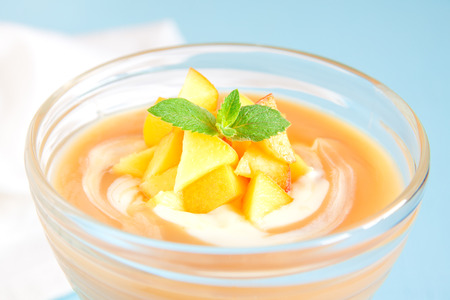 Peach dessert (mousse) with yogurt and mint on blue backgroundの写真素材
