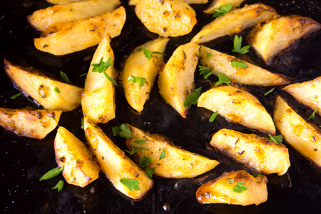 Homemade baked potatoes with spices and herbs close upの写真素材